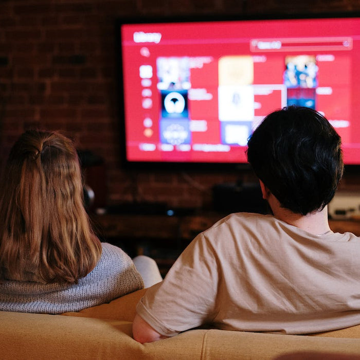 Two people following a Roku troubleshooting guide on TV