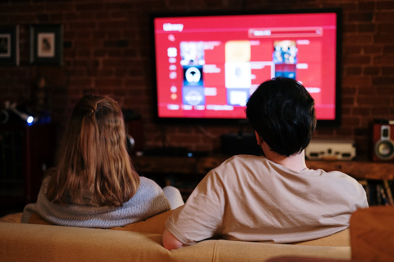 Two people following a Roku troubleshooting guide on TV