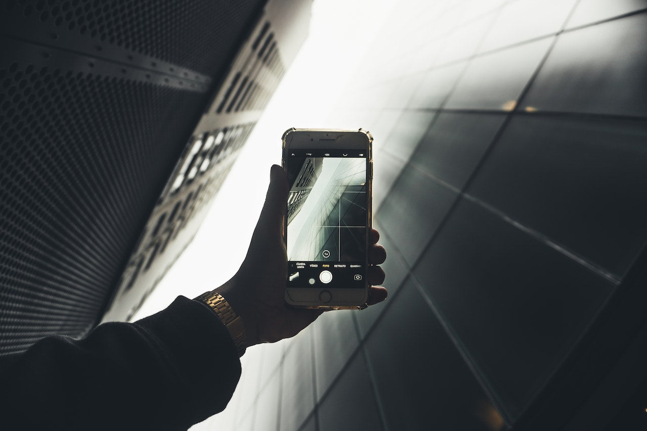 a person holding a smartphone and examining the camera lens, emphasizing the importance of selecting the perfect camera phone.