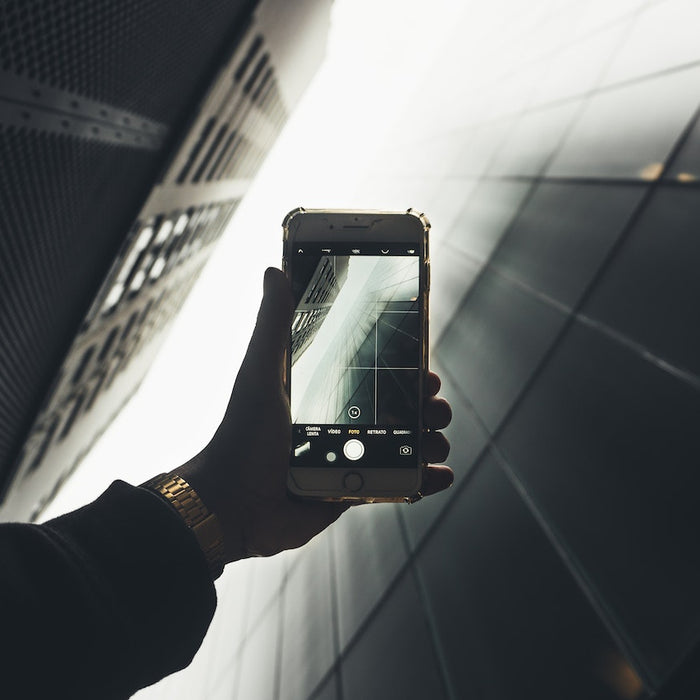 a person holding a smartphone and examining the camera lens, emphasizing the importance of selecting the perfect camera phone.